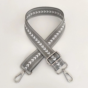 Close-up of adjustable grey nylon shoulder strap with white chevron pattern and silver hooks