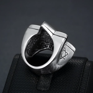 Macro detail of vintage stainless steel Star of David ring on black textured jewelry box