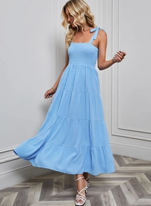 Détail d'une robe bleue à volants avec bustier plissé et fines bretelles à nouer