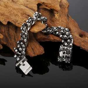Macro view of vintage silver skull link bracelet with intricate engraved box clasp detail