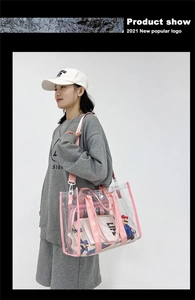 Clear PVC tote bag with pink webbing straps shown on a model in a casual setting