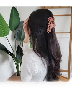 Detail of matte pink hollow rose hair claw clip worn in a Korean style hairstyle