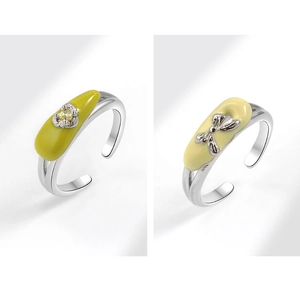 Detail of silver-tone open rings with macaron green and yellow enamel heart bow gems