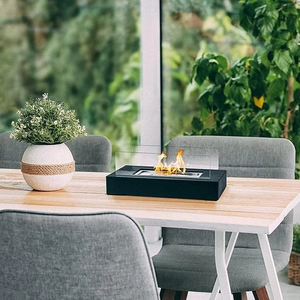 Rectangular tabletop alcohol fireplace with black base and glass guards on wooden table