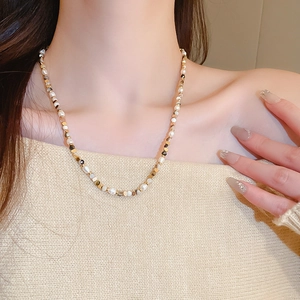 Detail of freshwater pearl and agate beaded necklace on model with vintage style