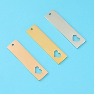 Three rectangular metal tags in rose gold, gold, and silver with hollow heart cutouts
