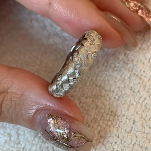 Detailed macro view of silver woven wide band ring with shimmering inlaid crystals