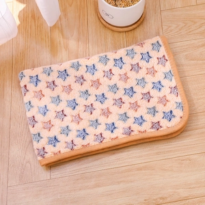 Detail of beige flannel pet blanket with multi-color star prints and reinforced edges