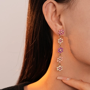Gros plan de boucles d'oreilles pendantes à fleurs avec strass roses et blancs sur mannequin