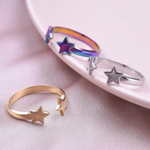 Adjustable stainless steel star rings in gold, silver and rainbow colors on satin background
