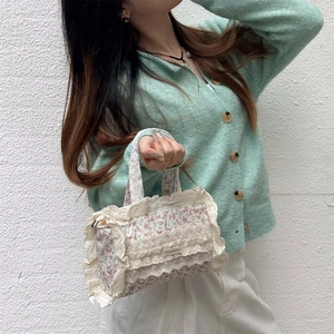 Sac cabas floral en toile avec bordure en dentelle porté par un mannequin en gilet menthe