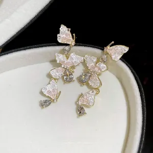 Detail of butterfly drop earrings with pink mosaic wings and sparkling crystals