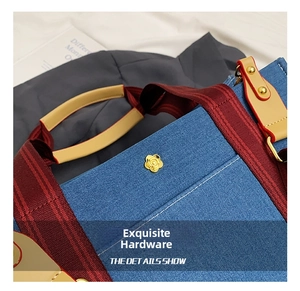 Macro view of blue denim tote bag with leather straps and golden camellia flower buckle