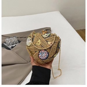 Detailed view of heart clutch bag featuring gold embroidery and colorful sequins