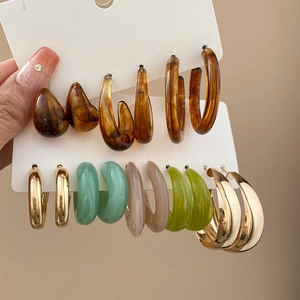 Detail of acrylic and silver needle earring set featuring tortoiseshell and pastel resin loops