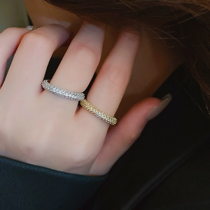 Close-up of stacked gold and silver plated eternity rings with micro-paved zircons