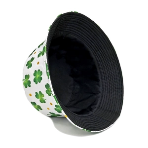 White bucket hat with green clover print and yellow dots from a 45-degree angle