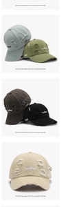 Detailed view of distressed baseball caps with letter embroidery and metal ring accents