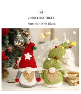 Close-up of handmade crochet Santa Claus and Christmas tree figures with festive lighting