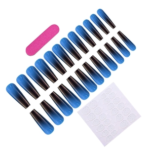 Close-up of long blue and black gradient fake nail set with nail file and adhesive glue tabs