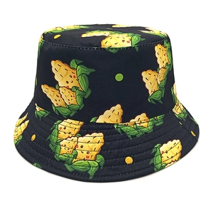 Close-up of a black bucket hat with cartoon corn pattern and yellow green polka dots