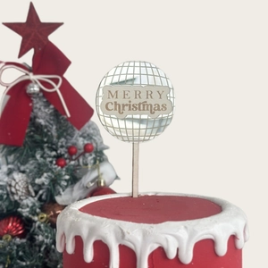 Mirror disco ball cake topper with Merry Christmas gold lettering on festive cake