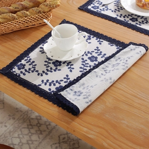 Retro blue floral cotton linen placemat with navy lace trim on a rustic wooden table