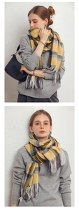 Detailed close-up showing the yellow and gray plaid cashmere-like scarf with fringe tassels