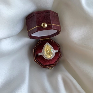 Close-up of a pear-cut honey yellow zircon ring in a luxury red velvet jewelry box