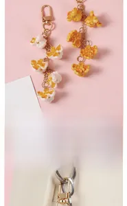 Detailed view of realistic PVC popcorn keychain hanging on a stylish light-colored bag