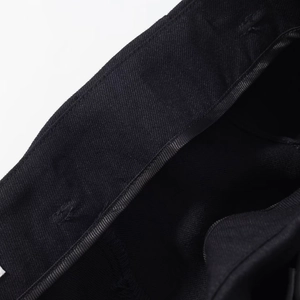 Macro shot of the black twill cotton fabric texture and neat stitching on the casual suit