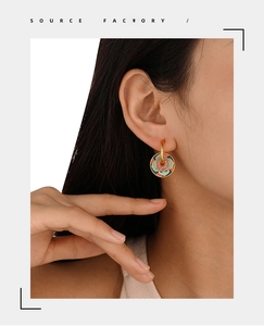 Detailed close-up of vintage Cloisonne style enamel flower earrings on model ear