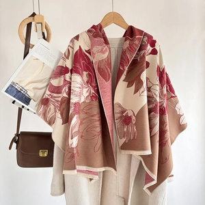 Detail of red floral cashmere-style shawl with tassels styled with a beige coat and bag