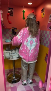 Detail of pink knit cardigan featuring blue and white jacquard pattern on back