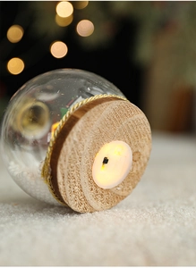 Detalle de la base de madera con interruptor en una bola de nieve navideña luminosa