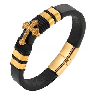 Detail of men's leather bracelet featuring a gold cross relief and metallic buckle