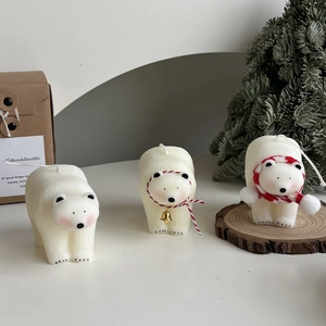 Polar bear scented candles with festive scarf and golden bell for home decor