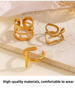 Detailed view of three 18K gold plated stainless steel rings with unique textured finishes
