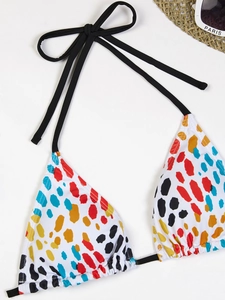 Detailed flat lay of polka dot print halter bikini top with straw hat and sunglasses decor