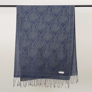 Dettaglio di sciarpa blu con motivo paisley, frange ed etichetta in 100% viscosa