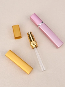 Detail view of portable perfume atomizer components with glass liner and metallic shell