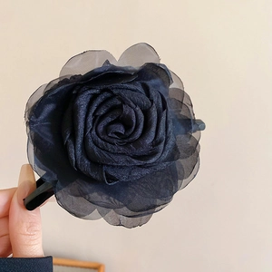 Makro-Detail einer schwarzen Organza-Rosen-Haarklammer mit geschichteten Blütenblättern