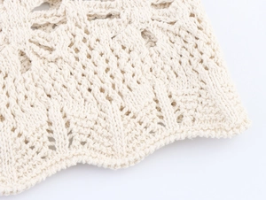 Detailed macro view of ivory crochet knit fabric with intricate geometric hollow patterns