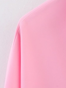 Close-up of the shoulder tailoring and premium pink woven fabric texture on a safari shirt