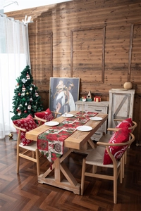 Detailed view of red and green Christmas table runner with festive tassels and floral motifs