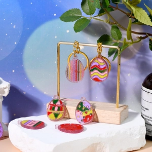 Detail of Easter egg resin charms with glitter finish and colorful patterns on gold rack
