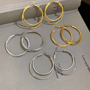 Detail view of 18k gold plated double layer hoop earrings with textured finish
