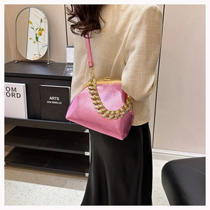 Detail of pink metallic leather crossbody bag featuring a vintage gold kiss-lock closure