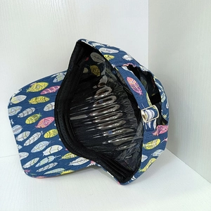 Detail of navy baseball cap with colorful feather patterns and adjustable metal buckle