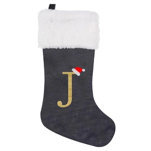 Detail of grey velvet Christmas stocking with white plush trim and embroidered golden letter J